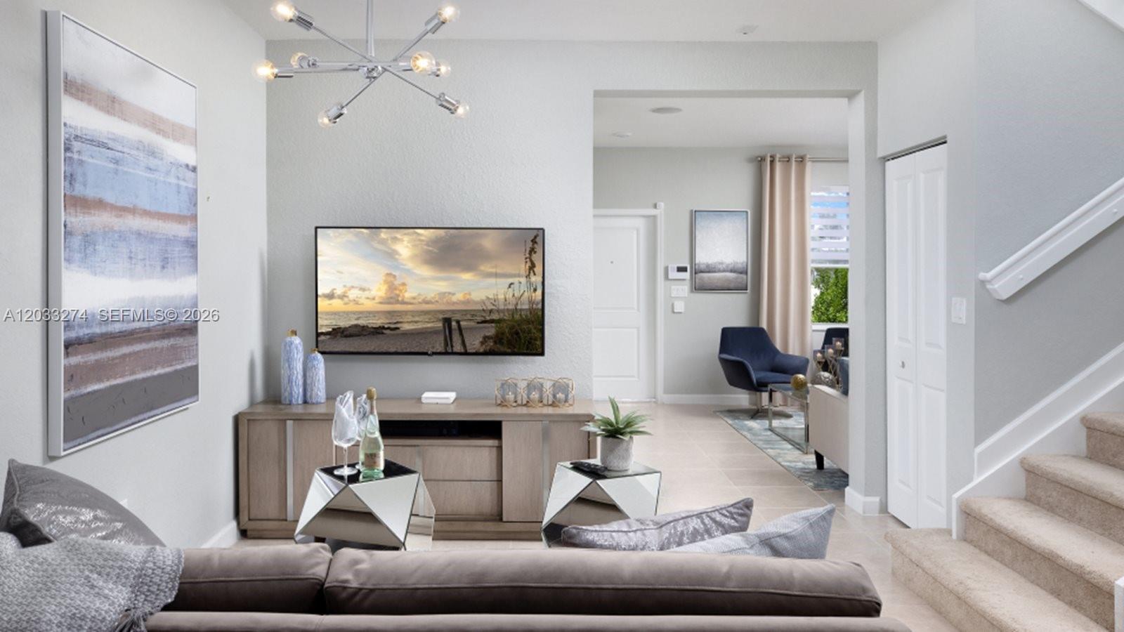 A living room features a wall-mounted television, a wooden media console, and a staircase — 2591 SE 26 CT, Homestead FL 33035, HOMESTEAD, FL