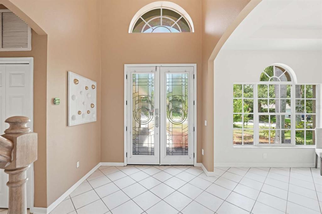 An entryway features a double front door with decorative glass, tile flooring, and high ceilings — 1837 BRILAND STREET, TARPON SPRINGS, FL