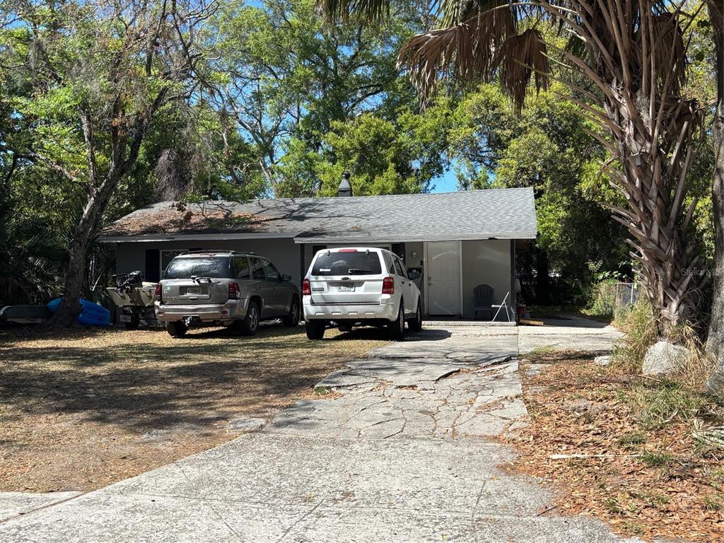 A single-story house with a gray exterior, a shingled roof, and two cars parked outside — 516 S DOLLINS AVENUE, ORLANDO, FL