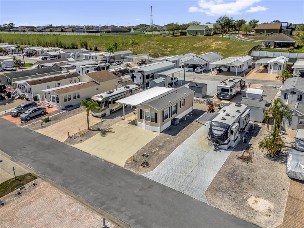 An aerial view shows a residential community with mobile homes, RVs, and paved driveways — 1039 CENTER CREST BOULEVARD, DAVENPORT, FL
