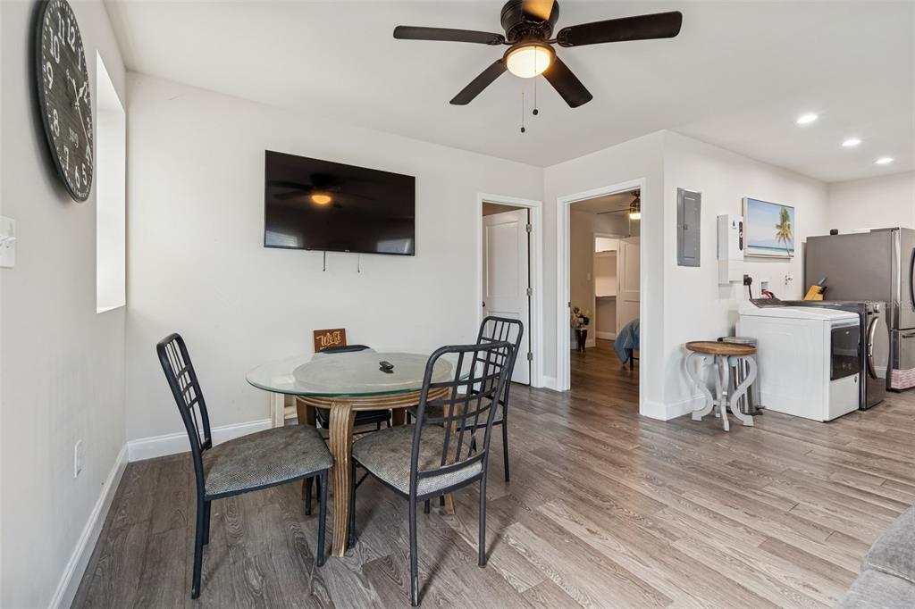 A dining area with a glass table, black chairs, and a wall-mounted television — 1006 E 26TH AVENUE, TAMPA, FL