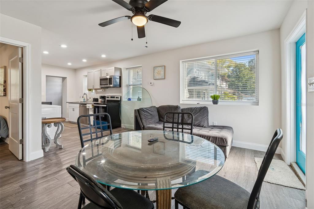 A dining area with a glass table and chairs opens into a kitchen with gray cabinets — 1006 E 26TH AVENUE, TAMPA, FL