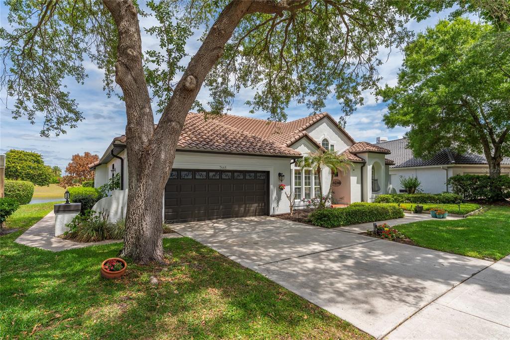 A single-story house with a tile roof, a two-car garage, and a concrete driveway — 7665 MOUNT CARMEL DRIVE, ORLANDO, FL