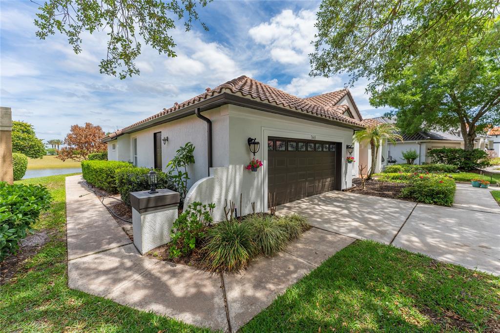 A single-story house exterior features a brown garage door, stucco walls, and a tiled roof — 7665 MOUNT CARMEL DRIVE, ORLANDO, FL