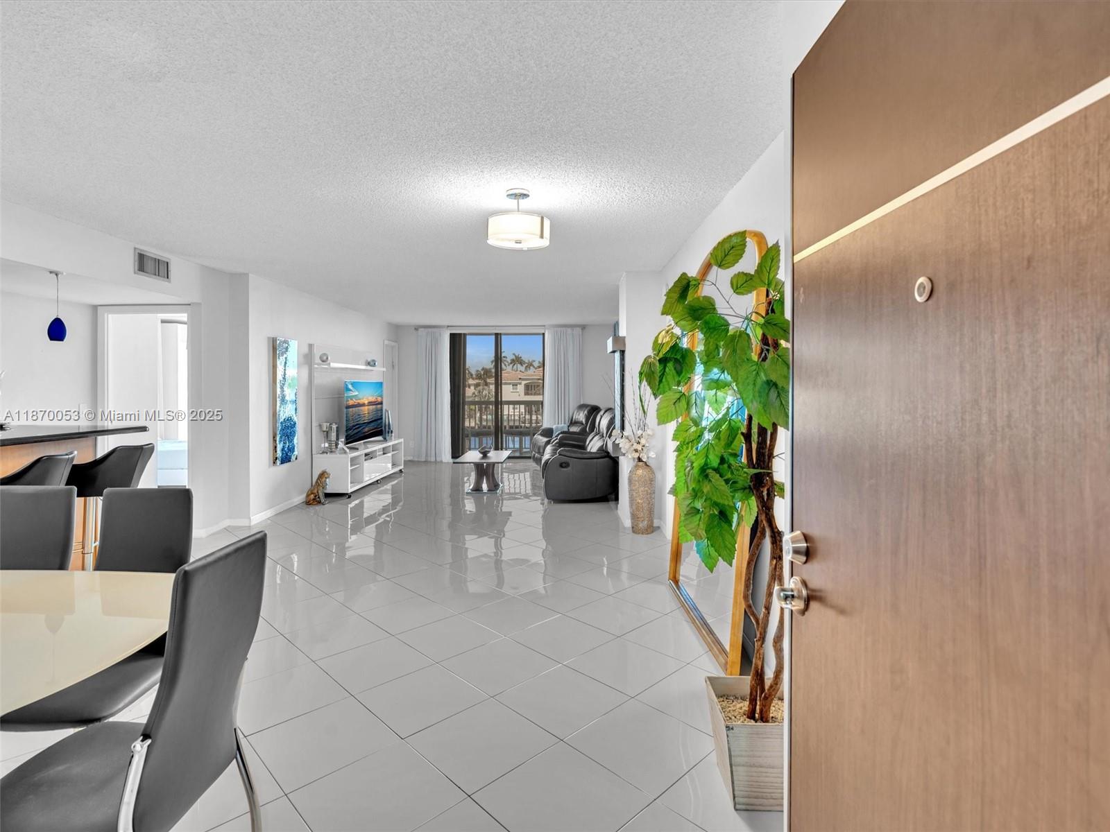An open-concept living and dining area features white tile floors and a balcony view — 1500 S Ocean Dr # 3E, Hollywood FL 33019, HOLLYWOOD, FL