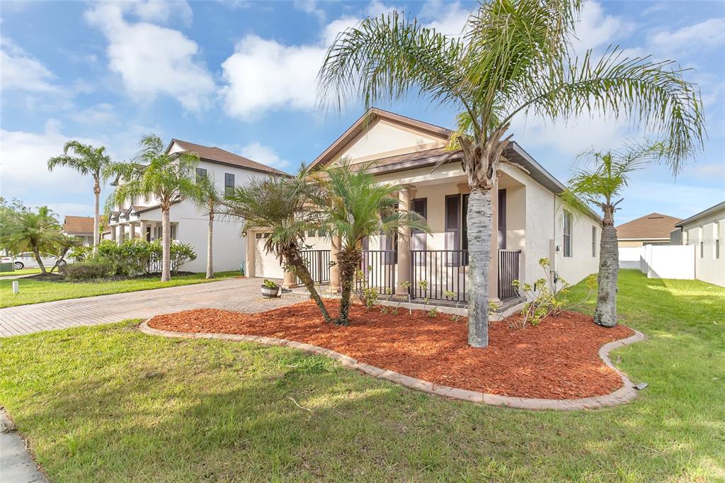 A single-story house with a paved driveway, palm trees, and a red mulch garden bed — 9837 OLD PATINA WAY, ORLANDO, FL