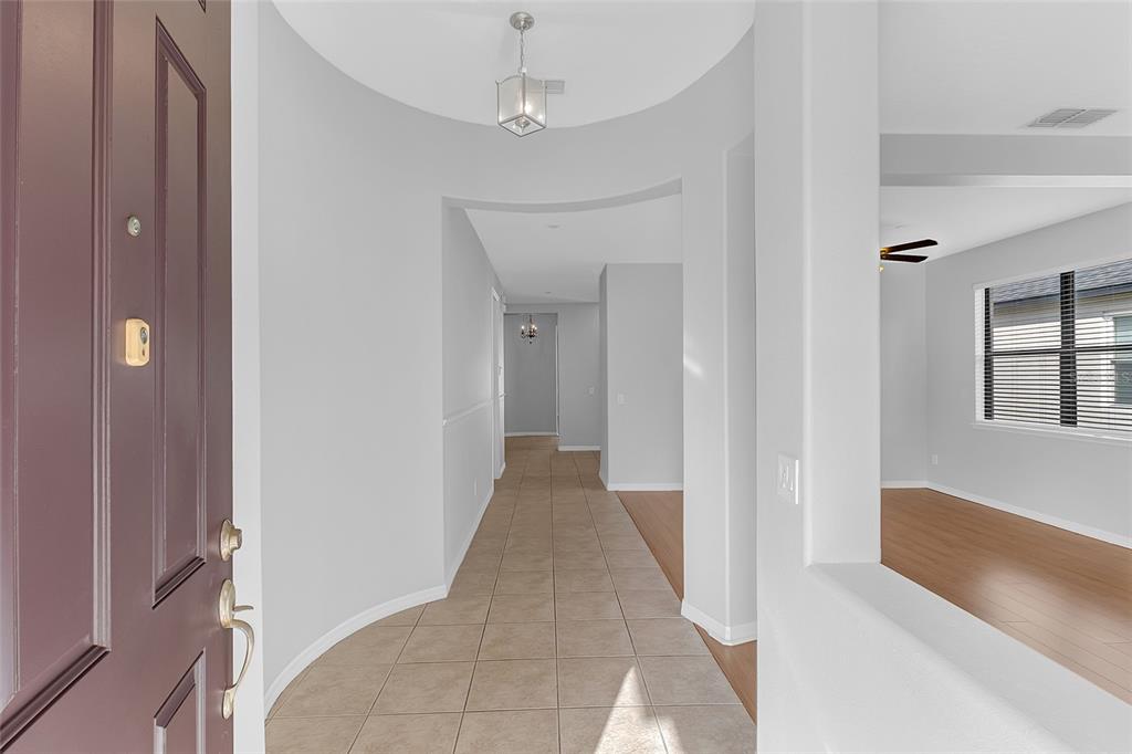 A tiled entryway leads into a hallway with light walls and a view of a room — 9837 OLD PATINA WAY, ORLANDO, FL