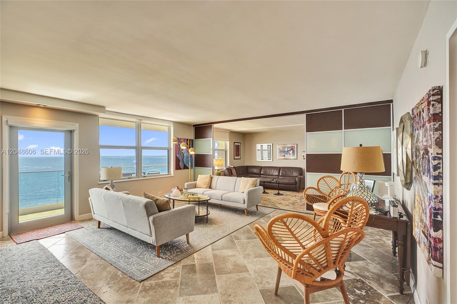 A living room features tile floors, a balcony with ocean views, and a sliding partition — 9225 Collins Ave # 1402, Surfside FL 33154, SURFSIDE, FL