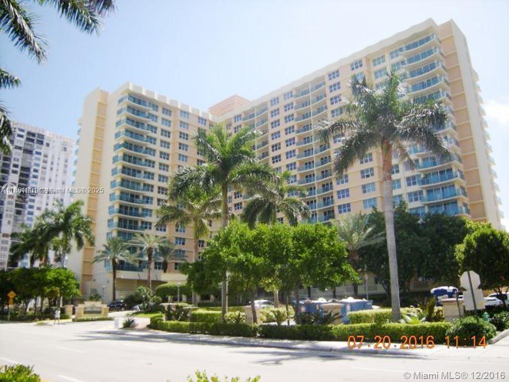 A multi-story residential building with balconies stands behind palm trees and landscaped grounds — 2501 S Ocean Dr # 336, Hollywood FL 33019, HOLLYWOOD, FL