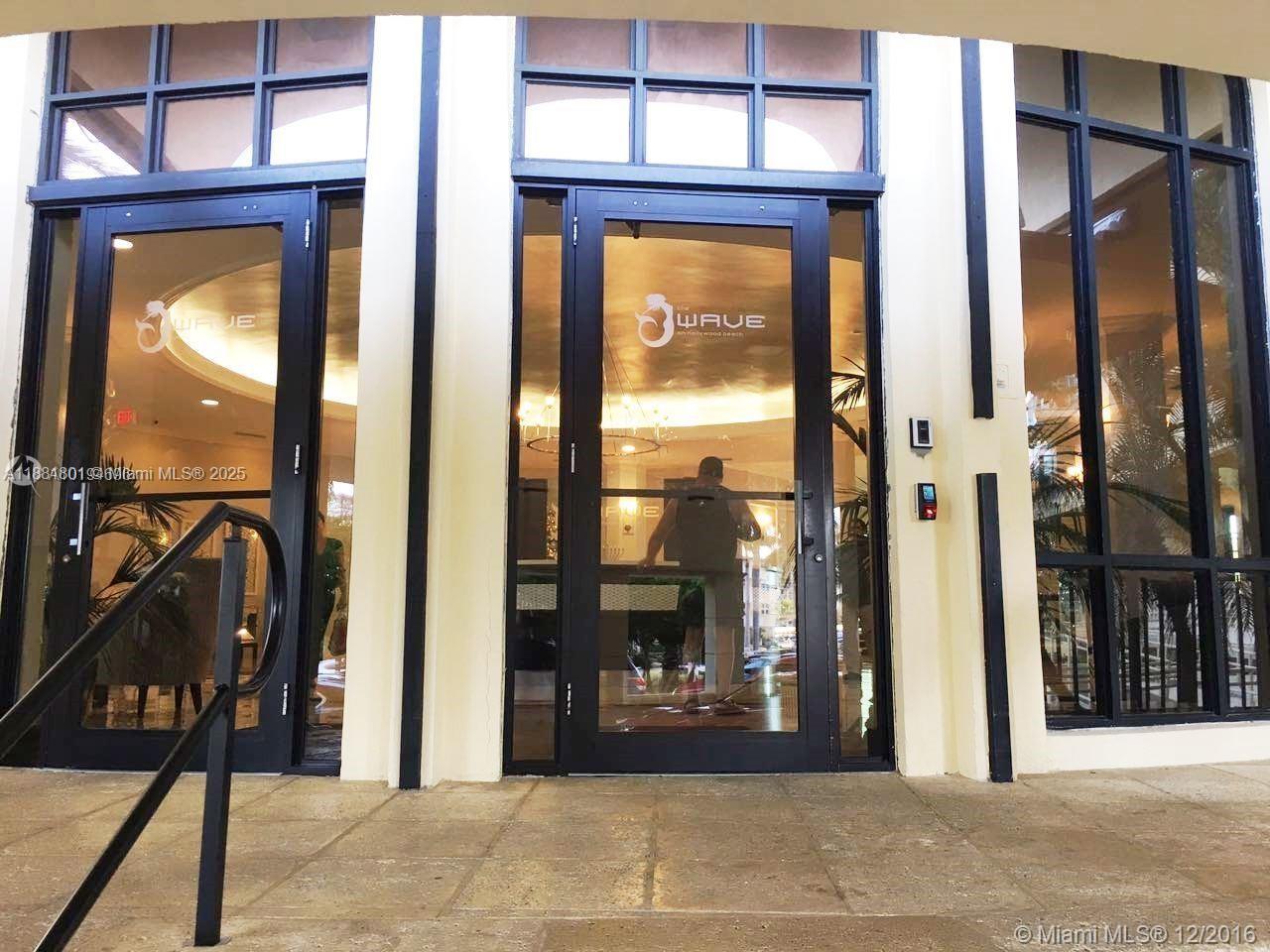 The exterior entrance of a building features glass double doors with black frames and signage — 2501 S Ocean Dr # 336, Hollywood FL 33019, HOLLYWOOD, FL