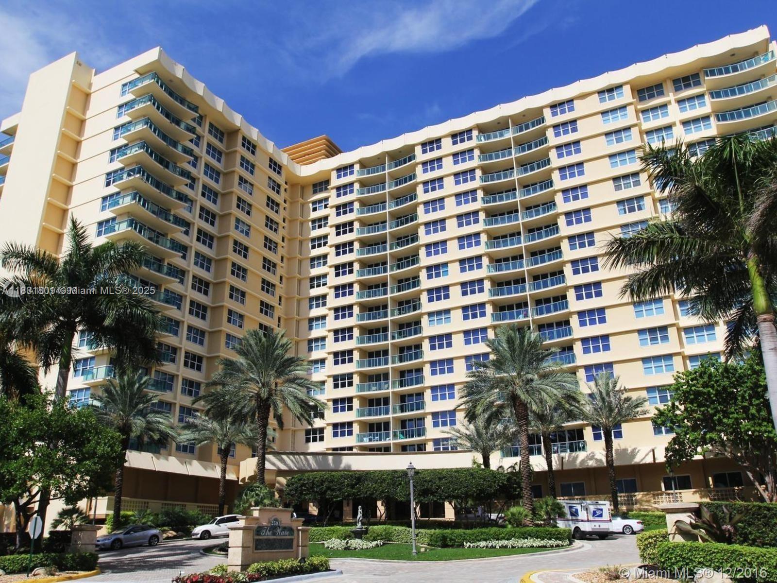 A multi-story beige residential building features numerous balconies and palm trees in the foreground — 2501 S Ocean Dr # 336, Hollywood FL 33019, HOLLYWOOD, FL