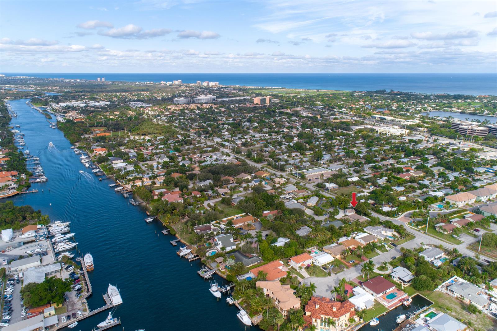An aerial view shows a residential neighborhood along a canal with a red arrow marker — 2016 Joy-rene Lane, North Palm Beach FL 33408, NORTH PALM BEACH, FL