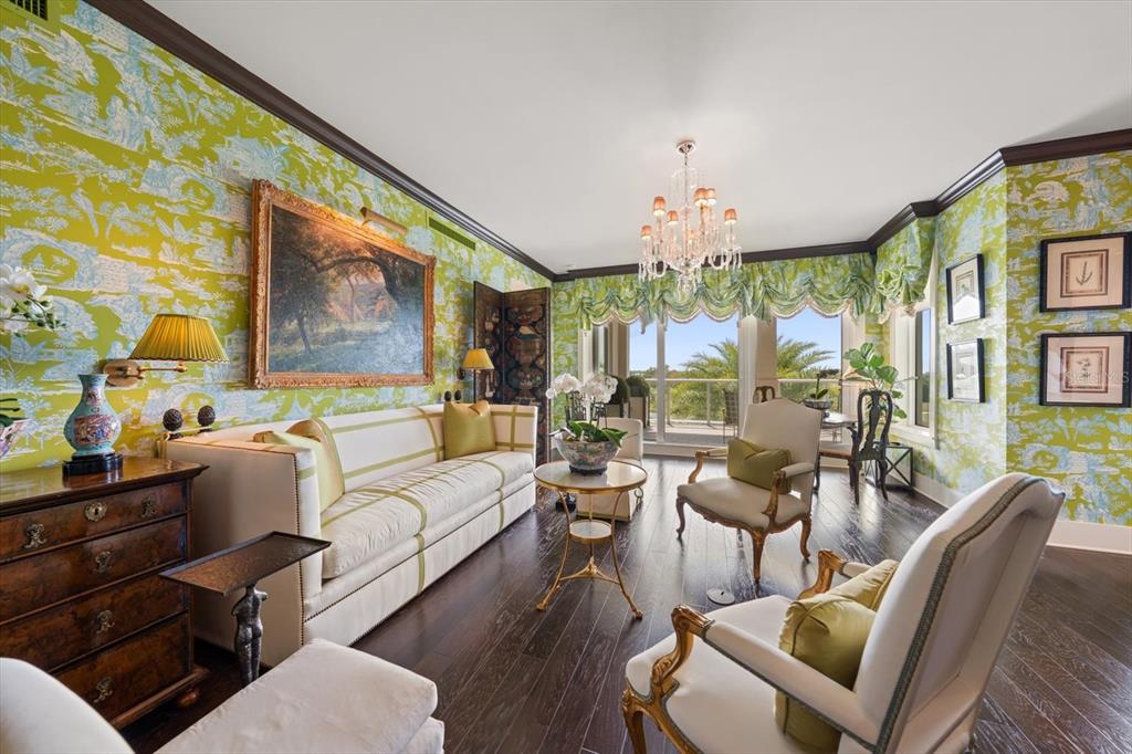A living room features bright green patterned wallpaper, a white sofa, and dark wood floors — 125 BELLEVIEW BOULEVARD UNIT 302, BELLEAIR, FL
