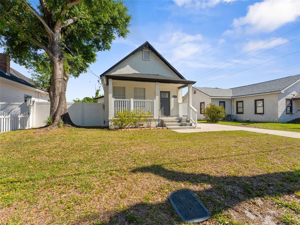 A single-story house with a front porch, white siding, and a large tree in front — 2903 W IVY STREET, TAMPA, FL