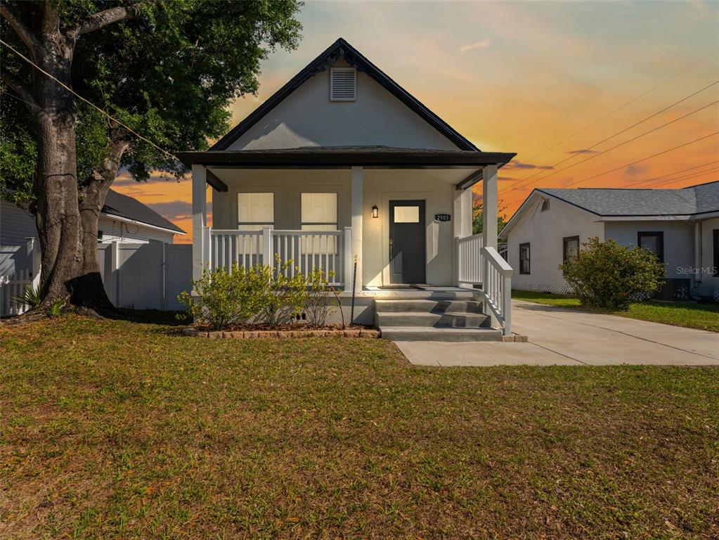 A single-story house with a front porch, concrete steps, and a driveway at sunset — 2903 W IVY STREET, TAMPA, FL
