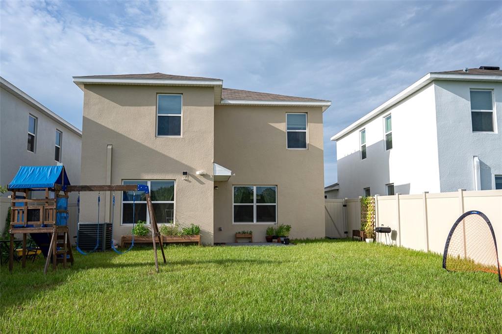 An aerial view shows a row of suburban houses with garages facing a large lake — 35606 KINSEY POINT, ZEPHYRHILLS, FL