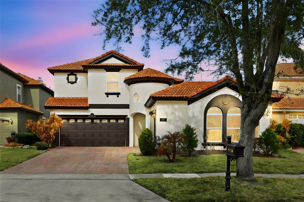 A two-story house with a terracotta tile roof, stucco exterior, and a two-car garage — 910 LASCALA DRIVE, WINDERMERE, FL