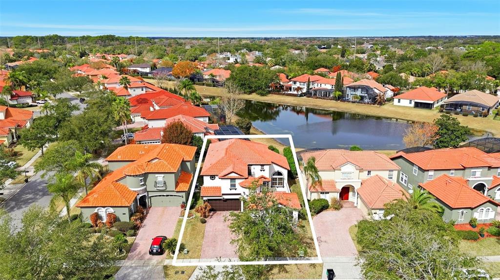An aerial view shows a two-story house with a red tile roof and a driveway — 910 LASCALA DRIVE, WINDERMERE, FL