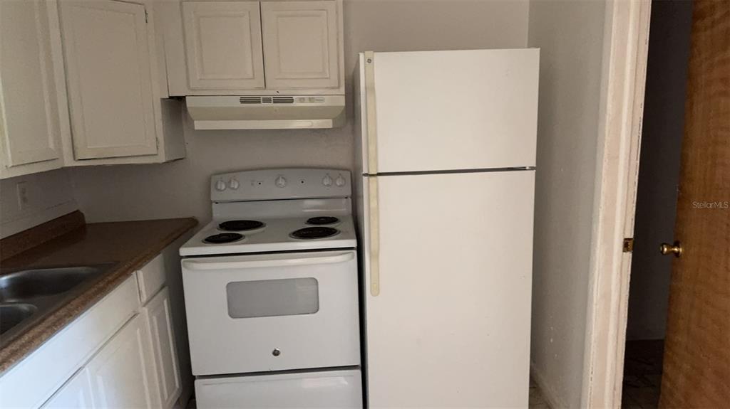 A kitchen features white cabinets, a white electric stove, and a white refrigerator — 1131 PHELPS STREET, JACKSONVILLE, FL