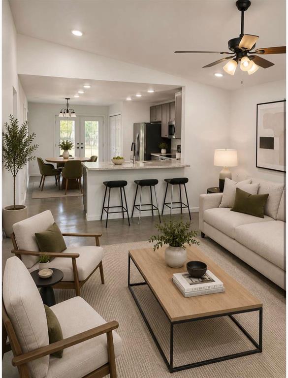 An open-concept living room and kitchen featuring neutral furniture, a ceiling fan, and concrete floors — 0 CORDOVA, AUBURNDALE, FL