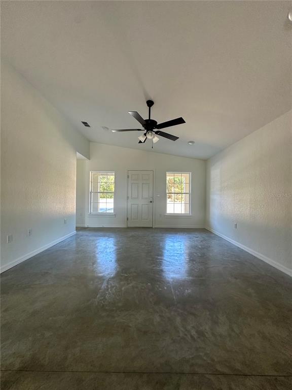 An empty room with white walls, a ceiling fan, and polished concrete flooring — 0 CORDOVA, AUBURNDALE, FL