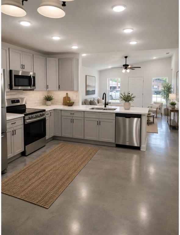 A modern kitchen with light gray cabinets, stainless steel appliances, and polished concrete floors — 0 CORDOVA, AUBURNDALE, FL