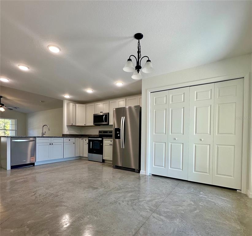 A kitchen features white cabinets, stainless steel appliances, and polished concrete floors — 0 CORDOVA, AUBURNDALE, FL
