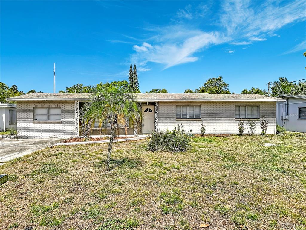 A single-story house with a light brick exterior, a palm tree, and a grassy yard — 4509 S HALE AVENUE, TAMPA, FL