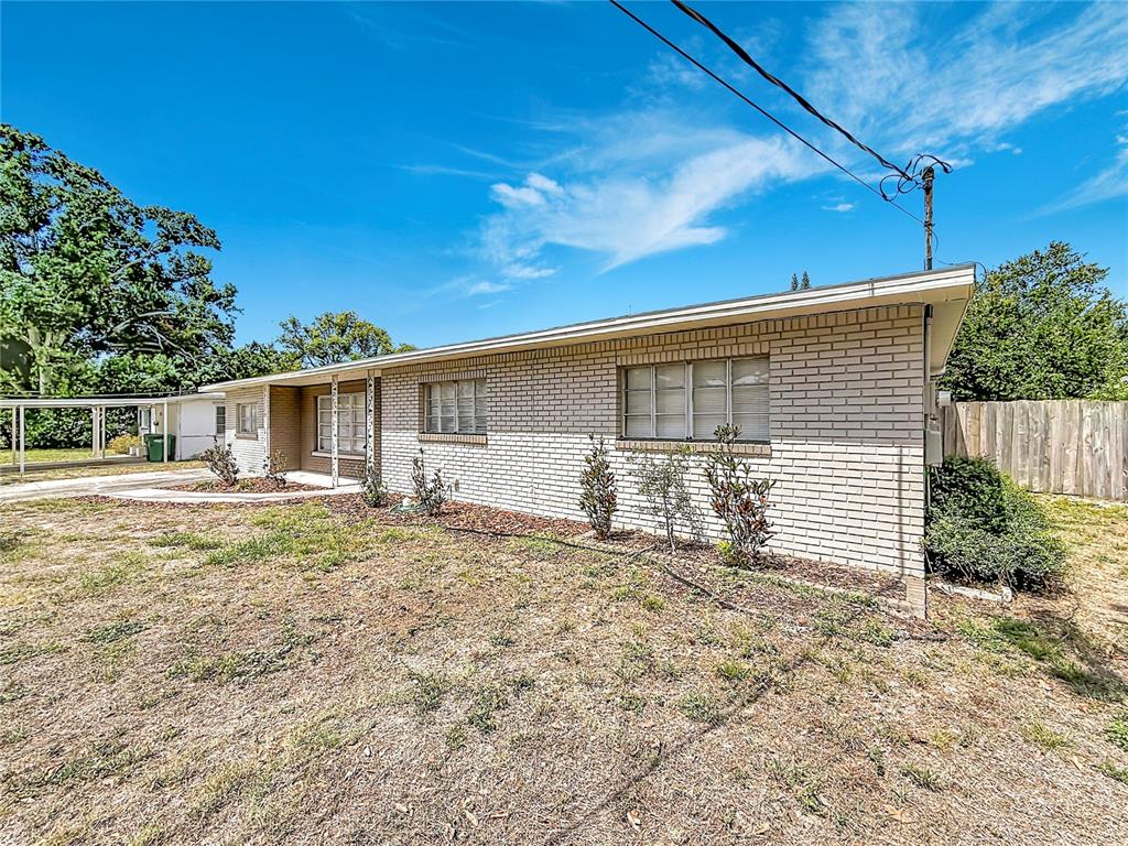 A single-story brick house features a flat roof, horizontal windows, and a dry lawn — 4509 S HALE AVENUE, TAMPA, FL