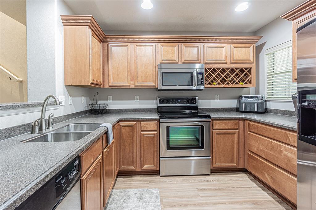 A kitchen features wood cabinets, stainless steel appliances, and gray speckled countertops — 526 WHEATON TRENT PLACE, TAMPA, FL