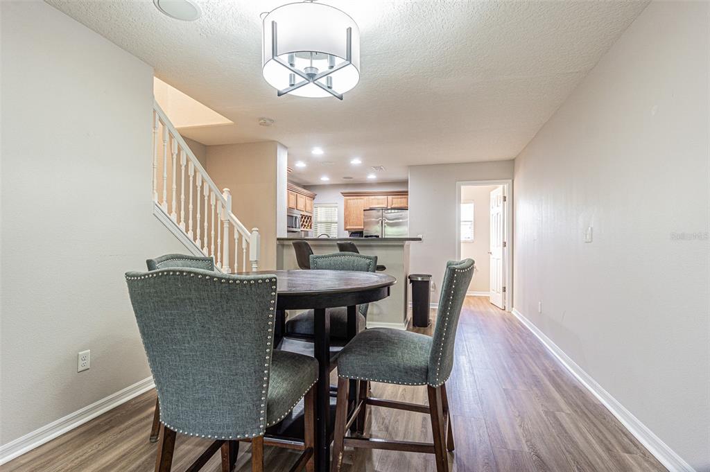 A dining area with a round table and chairs sits in front of a kitchen — 526 WHEATON TRENT PLACE, TAMPA, FL