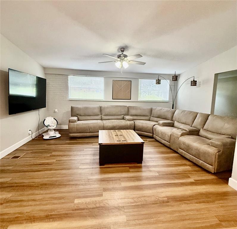 A living room features a large sectional sofa, a coffee table, and a wall-mounted television — 217 KELLY STREET S, LAKE HAMILTON, FL