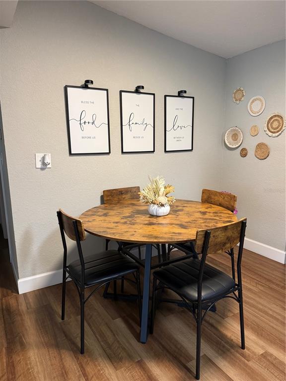 A dining area features a round wooden table, four chairs, and wall-mounted art — 217 KELLY STREET S, LAKE HAMILTON, FL