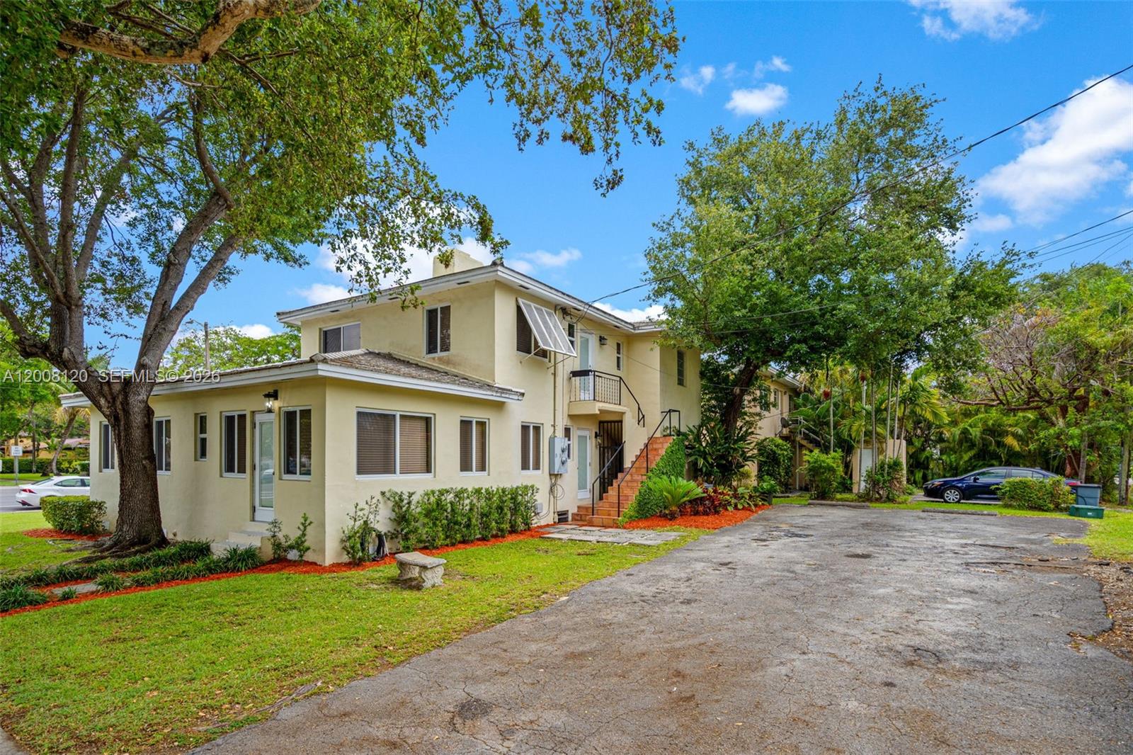 A two-story yellow apartment building with an exterior staircase and a paved parking lot — 3500 Ponce De Leon Blvd, Coral Gables FL 33134, CORAL GABLES, FL