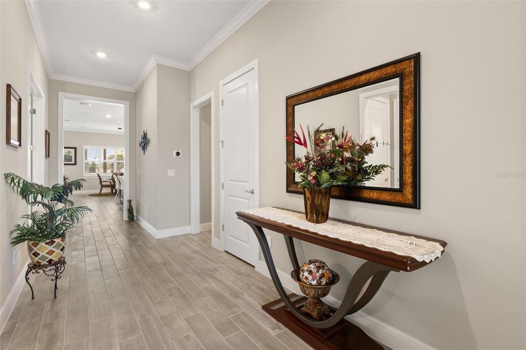 A hallway features light-colored tile flooring, a console table with a mirror, and a plant — 15351 WILLOW RIDGE DRIVE, MONTVERDE, FL