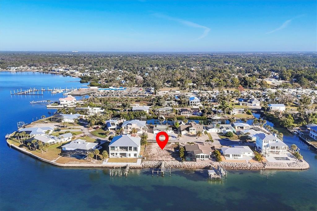 An aerial view shows a vacant waterfront lot marked with a red pin — 16 SOUTHWIND DRIVE, ENGLEWOOD, FL