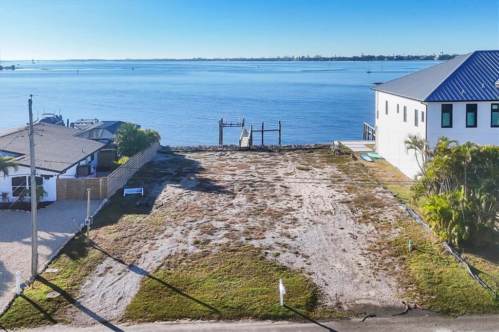 An elevated view shows a vacant waterfront lot situated between two houses — 16 SOUTHWIND DRIVE, ENGLEWOOD, FL