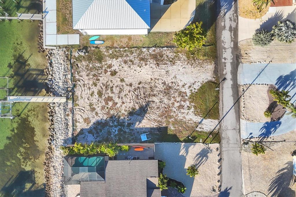 An aerial view shows a vacant waterfront lot situated between two existing houses — 16 SOUTHWIND DRIVE, ENGLEWOOD, FL