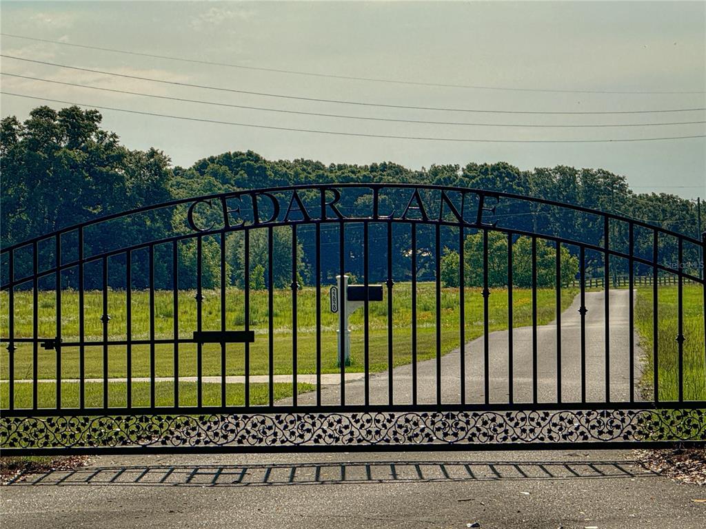 A black metal gate with the words Cedar Lane marks the entrance to a driveway — 00 NW 165TH AVENUE, HIGH SPRINGS, FL
