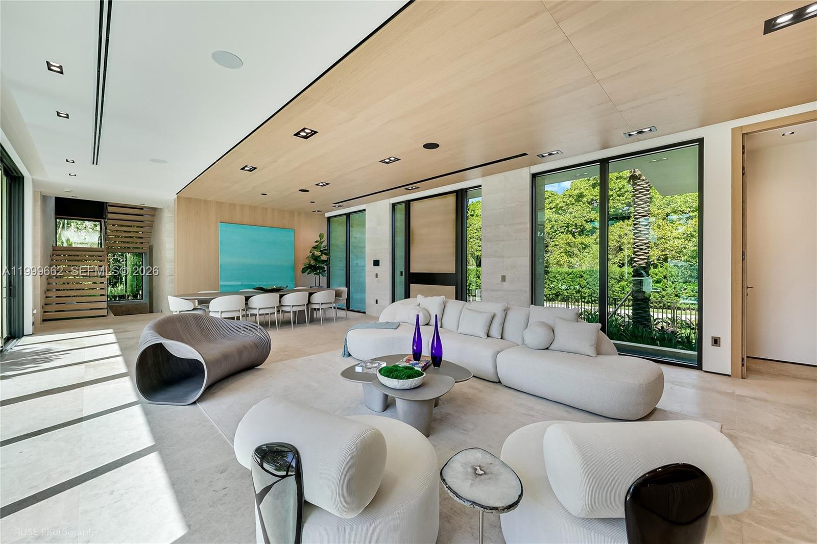 A modern living and dining area features a wood-paneled ceiling, large windows, and contemporary furniture — 770 Lake Rd, Miami FL 33137, MIAMI, FL