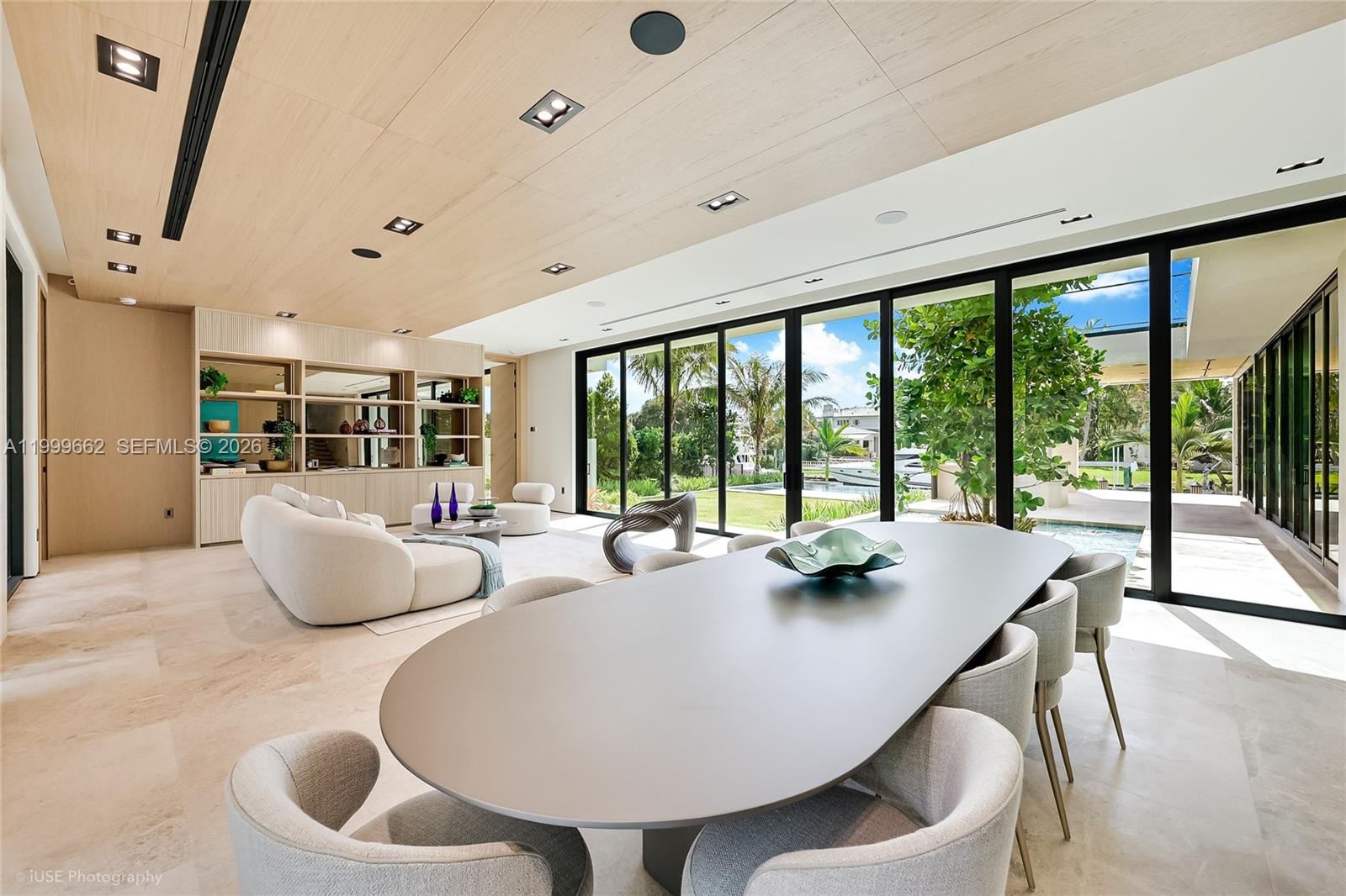A modern open-plan living and dining area features floor-to-ceiling glass walls overlooking a pool — 770 Lake Rd, Miami FL 33137, MIAMI, FL