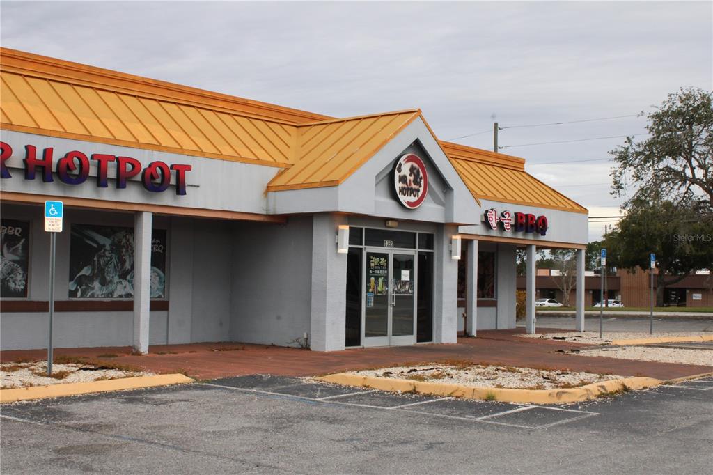 A commercial building with a yellow metal roof and signage for a hotpot restaurant — 5399 COMMERCIAL WAY, SPRING HILL, FL