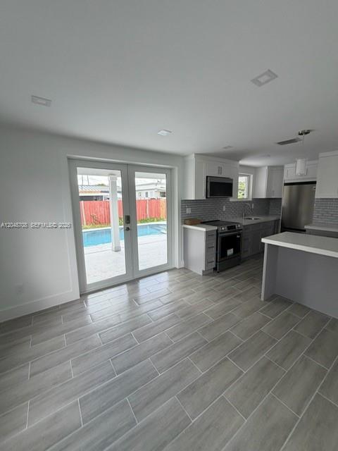 A kitchen with gray tile flooring opens to a patio through double glass doors — 3515-3517 SW 91st Ave, Miami FL 33165, MIAMI, FL