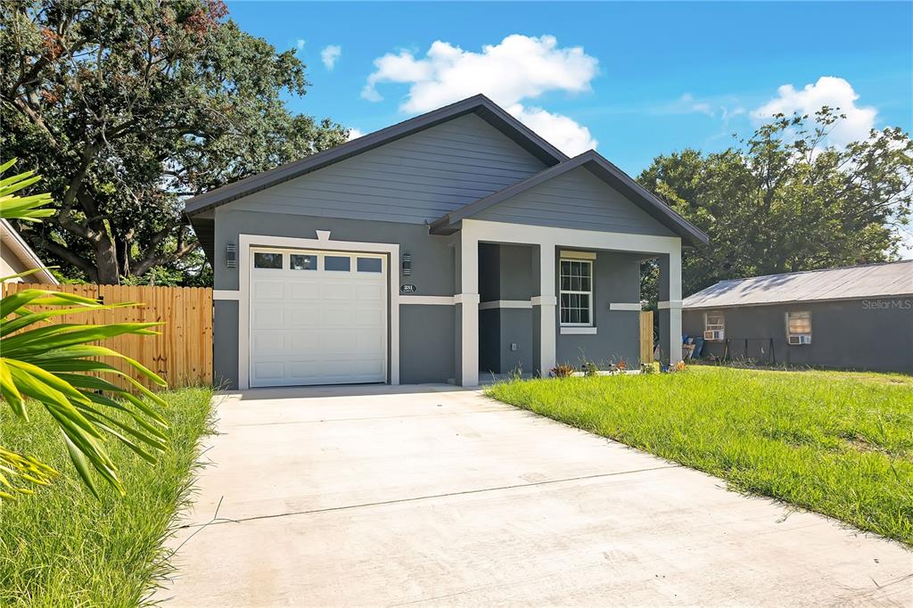 A gray single-story house with a white garage door, concrete driveway, and a covered porch — 231 E LAFAYETTE STREET, WINTER GARDEN, FL