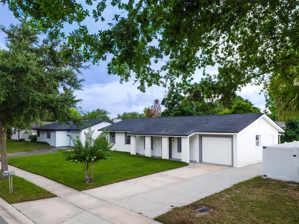 A white single-story house with a dark shingled roof and an attached garage — 377 JEFFERSON DRIVE, CASSELBERRY, FL