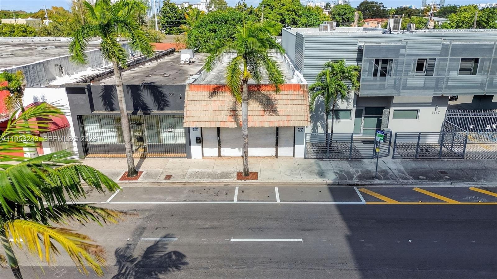 An exterior view of a commercial building with a tiled awning and adjacent modern structure — 2151 SW 8th St, Miami FL 33135, MIAMI, FL