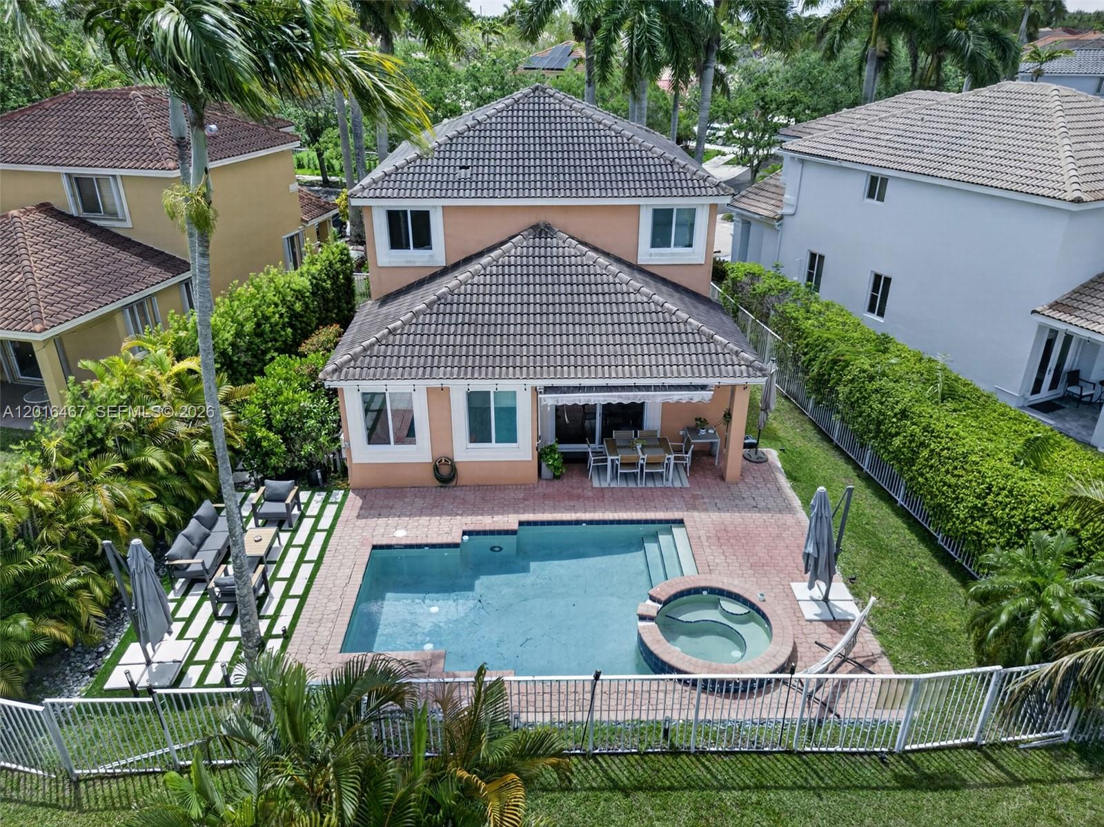 An aerial view of a two-story peach house with a pool, spa, and patio area — 250 Conservation Dr, Weston FL 33327, WESTON, FL