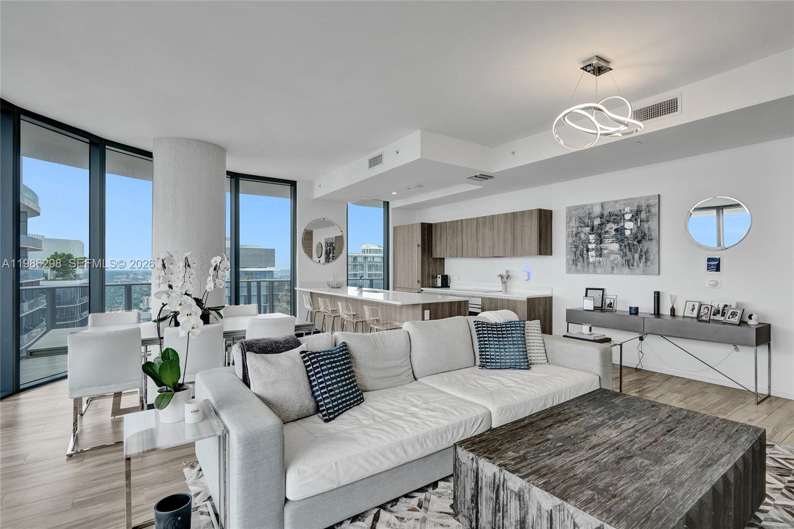 A modern open-concept living room features a kitchen, dining area, and floor-to-ceiling windows — 801 S Miami Ave # 4901, Miami FL 33130, MIAMI, FL