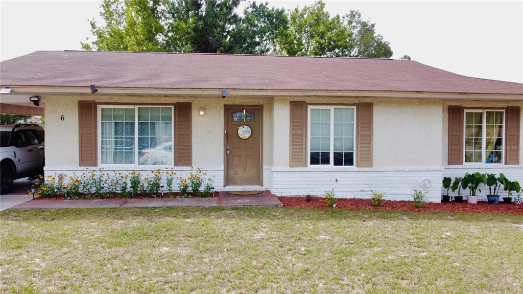 A single-story house with a white brick base, beige stucco walls, and a brown roof — 6 SPRING LANE WAY, OCALA, FL