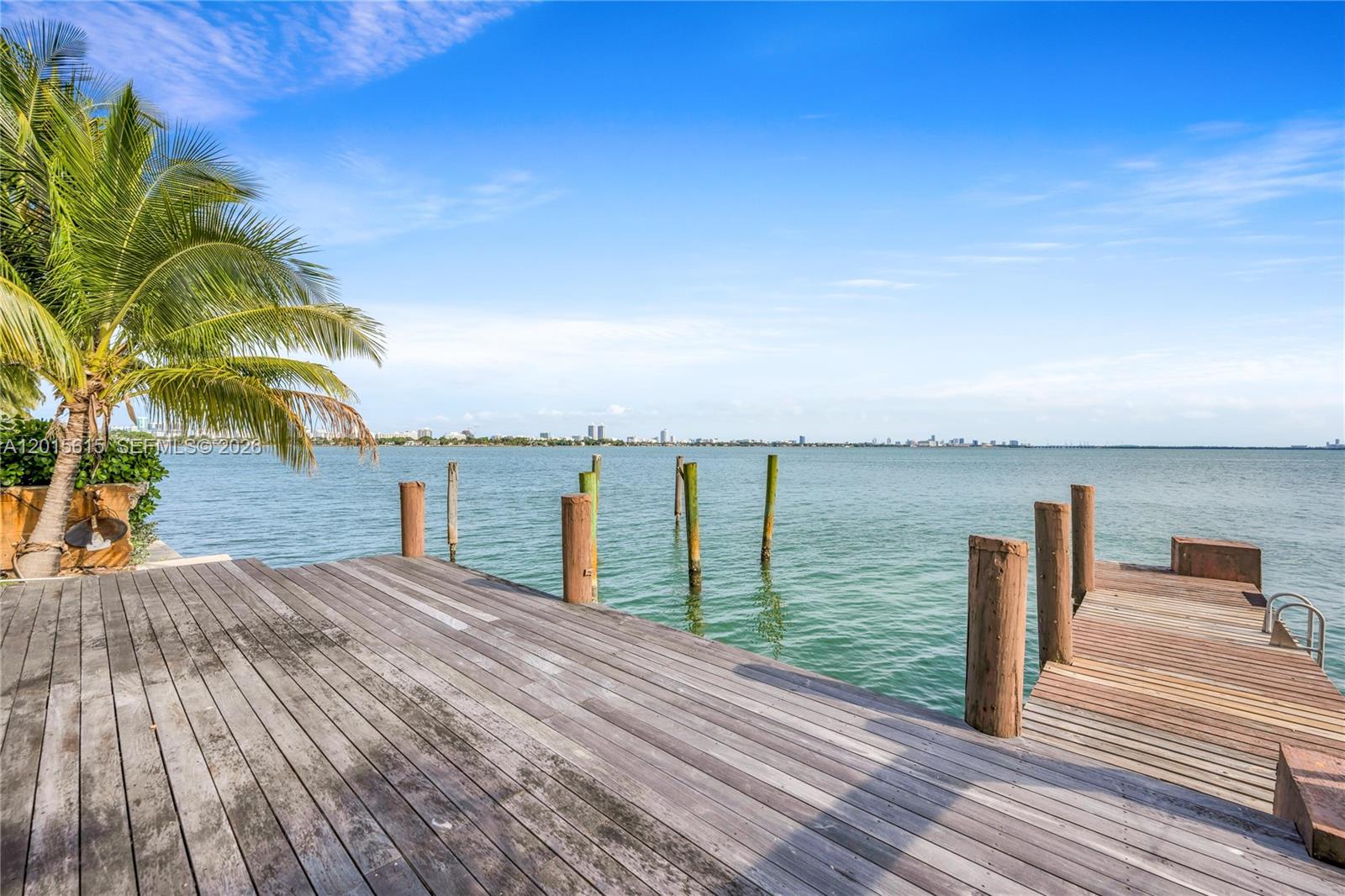 A wooden dock extends into the water with a palm tree on the left — 1920 Bay Dr, Miami Beach FL 33141, MIAMI BEACH, FL